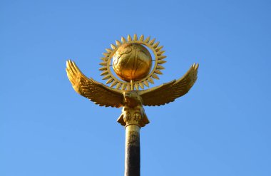Kazakistan sembolleri: altın kartal ve temiz mavi gökyüzünde altın güneş.