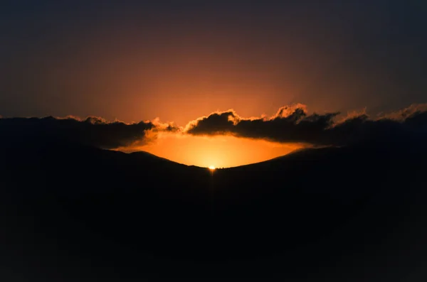 山のシルエットと赤い夕日 — ストック写真