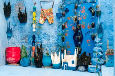 eski kapılar, mavi duvar ve yeşil bitkiler ile mavi şehir: chefchaouen sokaklarında