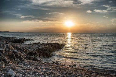 Kayalık sahil ile denize güzel gün batımı
