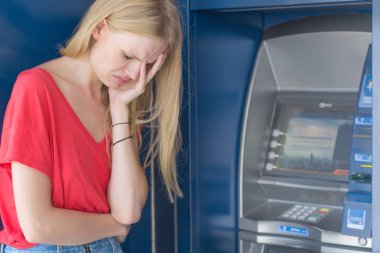 Bir Atm banka makine önünde duran üzgün kadın. Para yok.