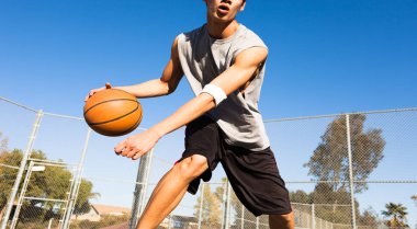 Genç atletik adam mahkeme dışında bir basketbol oyun oynuyor. Spor ve eğitim.