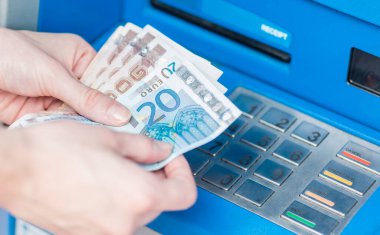 ATM 'deki para çekme makinesinden çekilen Euro' ları sayan bir erkek eli..