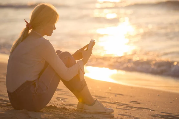 Mujer Joven Relajada Usando Teléfono Móvil Mientras Sienta Arena Playa Imagen De Stock