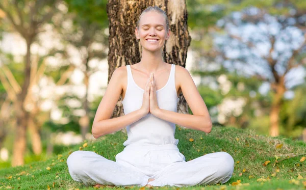 Glückliche Frau Die Yoga Praktiziert Und Meditiert Während Sie Gras Stockbild