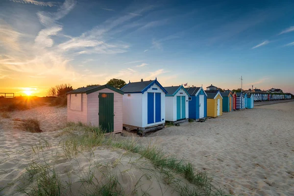 サウスウォルドのビーチ小屋の列に沈む夕日 — ストック写真