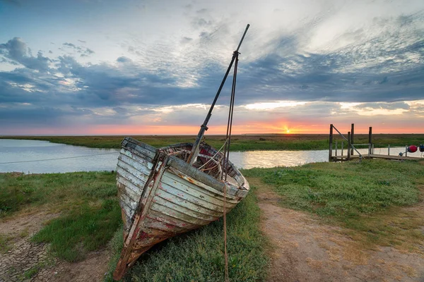 Soluppgång över övergiven fiskebåt på stranden vid Thornham — Stockfoto