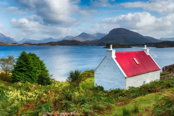 En vacker Croft med ett rött tak ser ut över Loch Shieldaig — Stockfoto