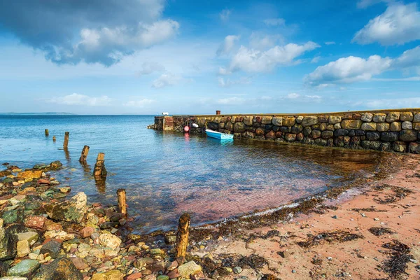 Un petit bateau amarré à une vieille jetée de pierre à Sannox — Photo