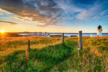Beautiful sunset over the lighthouse and coastguard cottages at Arnish Point near Stornoway on the Isle of Lewis in the Outer Hebrides of Scotland clipart
