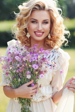 Alan Mor çiçek bir buket bir parkta Kıvırcık sarışın