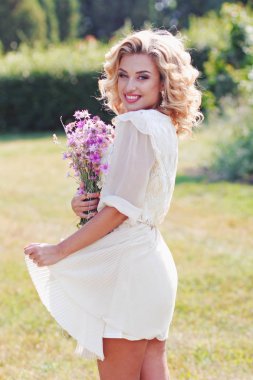 Alan Mor çiçek bir buket bir parkta Kıvırcık sarışın