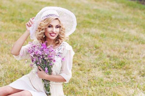 Кудрявая Блондинка Белой Шляпе Гуляет Парке Букетом Полевого Фиолетового Цветка — стоковое фото