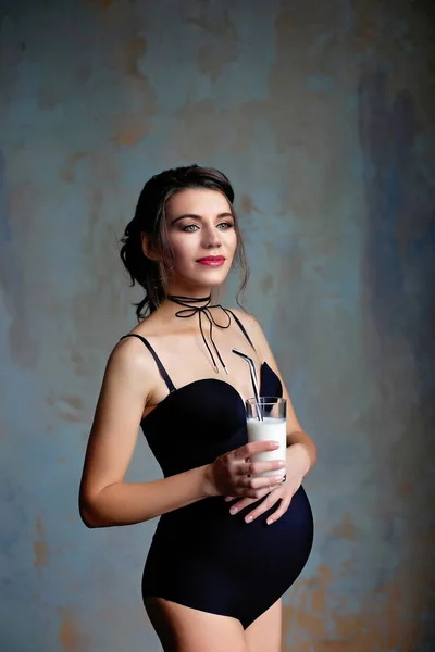 性感的黑发怀孕女孩与一杯牛奶在她的手中 — 图库照片