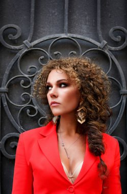 Kırmızı iş takım elbiseli güzel bir kıvırcık saçlı kadın CIT yürüyor