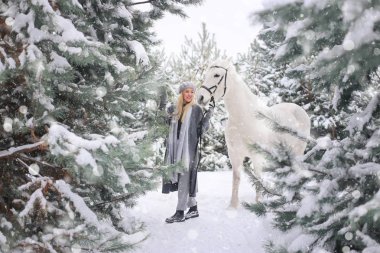 Mutlu genç gülümseyen çekici sarışın kadın ile at, kış günü bulutlu