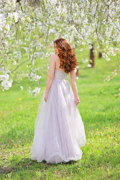 美丽的年轻温柔的女孩在樱花花园在春日 花瓣从树上落下 — 图库照片