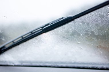 Araba sileceği yağmur damlalarını ön camdan siler. Güçlü duş. Kirli pencere. Pencere temizleniyor.