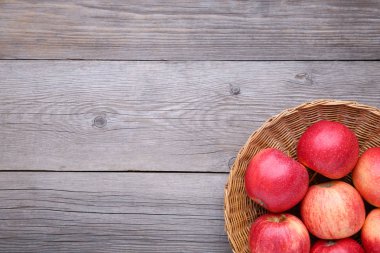 Ahşap arka plan üzerinde taze kırmızı elma. Gri zemin üzerine lezzetli elma