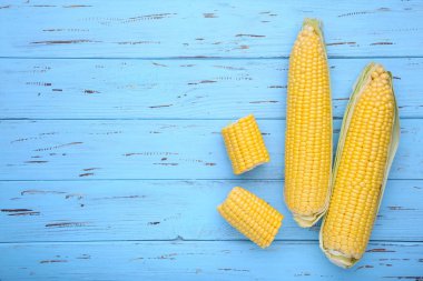 Taze mısır koçanı üzerinde mavi ahşap masa, closeup üzerinde