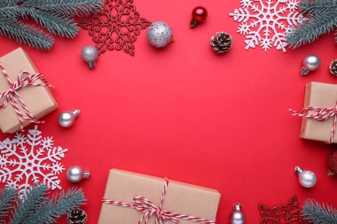 Noel hediyeleri süslemeler üzerinde kırmızı bir arka plan sunar. Yeni yıl kompozisyon
