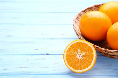 Olgun turuncu meyve sepeti mavi ahşap arka plan üzerinde