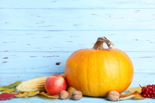 Orangener Kürbis Mit Roten Und Orangefarbenen Blättern Auf Blauem Hintergrund — Stockfoto