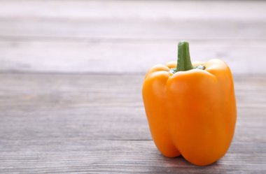 Gri bir ahşap masa üzerinde sarı biber