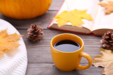 Kahve ile sonbahar yaprakları, kabak, kazak ve ahşap arka plan üzerinde eski kitap