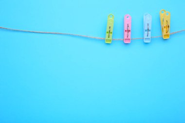 Halat mavi arka plan üzerinde renkli elbise iğneleri