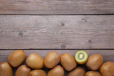 Taze kivi düz gri ahşap zemin üzerinde yatıyordu