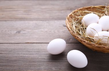 Sepette gri ahşap zemin üzerine tavuk yumurtası. Gri bir ahşap masa üzerinde yumurta