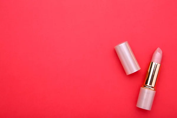 Nude lipstick on red background. Cosmetic