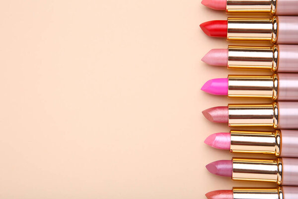 Many colorful lipstick on beige background. Cosmetic
