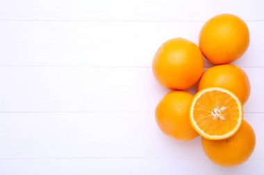 Beyaz bir arka plan üzerinde taze turuncu meyve. Beyaz ahşap bir masa üzerinde turuncu meyve