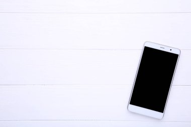 Beyaz ahşap masa boş ekran ile cep telefonu. Smartfone beyaz