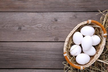 Sepette gri ahşap zemin üzerine taze tavuk yumurtası
