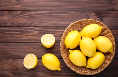 Taze limon sepeti kahverengi zemin üzerinde. Limon kahverengi ahşap tablo
