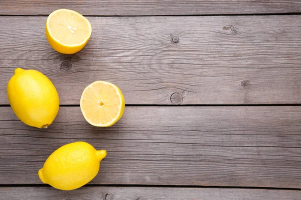 Lemon and half of lemon on grey background. Fresh tropical fruit.