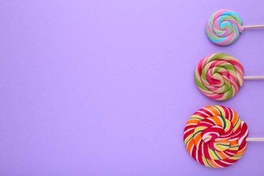 Mor arka plan üzerinde renkli lolipop. Stüdyo vurdu