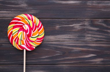 Kahverengi arka plan üzerinde renkli lolipop. Stüdyo vurdu