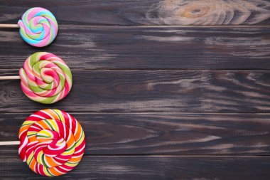 Kahverengi arka plan üzerinde renkli lolipop. Stüdyo vurdu