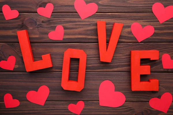 红色字母爱与木心在棕色背景 棕色上的爱情词 — 图库照片