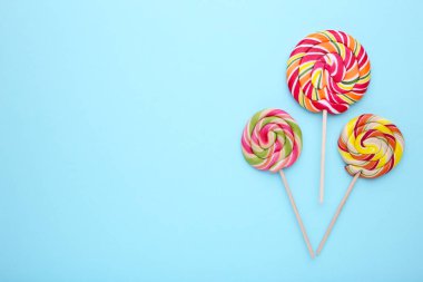 Mavi arka plan üzerinde renkli tatlı lolipop