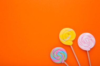 Turuncu arka plan üzerinde renkli lolipop. Stüdyo vurdu