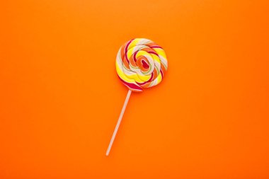 Turuncu arka plan üzerinde renkli lolipop.