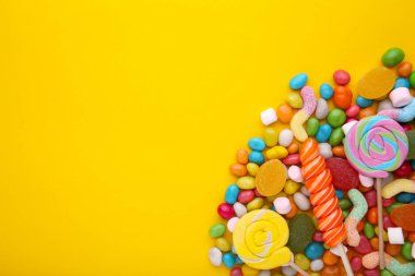 Renkli lolipop ve farklı renkli şeker sarı yuvarlak