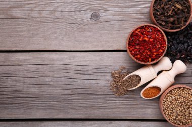 Gri zemin üzerine tahta kaşıklar üzerinde baharat karışımı.