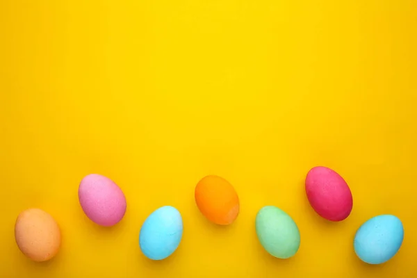 Oeufs de Pâques colorés sur un fond jaune — Photo