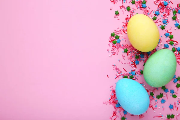Huevos coloridos de Pascua con salpicaduras sobre un fondo rosa — Foto de Stock